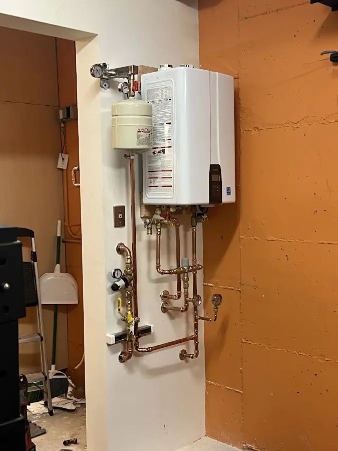 Plumbing technician inspecting water heater connections in Alva